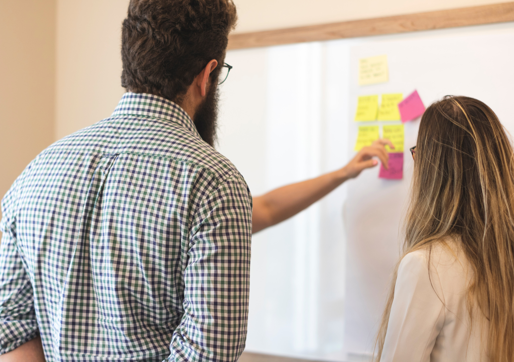 trois-personnes-discutant-sur-un-tableau-de-post-it trois-personnes-discutant-sur-un-tableau-de-post-it